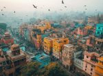 Photograph of Indian city, aerial view, buildings, few bird in the air, pink and gray tones, beige buildings, vibrant colors, daylight, cinematic. --ar 3:2 --stylize 250 --v 6.1 Job ID: a803aa4a-b6e5-427f-ad16-3f14ab3d15eb